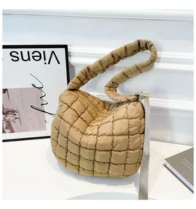 Macro view of khaki quilted cloud bag showing soft padded texture and crossbody strap