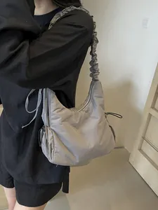 Modern grey padded nylon shoulder bag featuring creative ruched cloud-style wide strap
