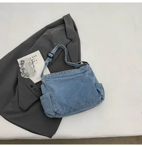 Detail of blue denim tote bag showing side pocket and adjustable shoulder strap