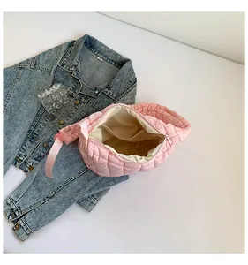 Macro detail of pink quilted cloud bag featuring puff texture, zipper and denim jacket accent
