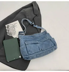 Detail of blue denim tote bag with cargo pockets and adjustable shoulder strap