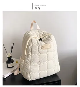 Detail of off-white quilted backpack featuring soft padded texture on a black desk