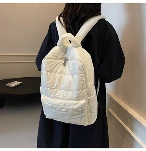 Close-up of lightweight white quilted puffy backpack showing soft padded straps and texture