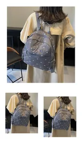 Detail of gray quilted backpack with white embroidered bows and soft padded texture