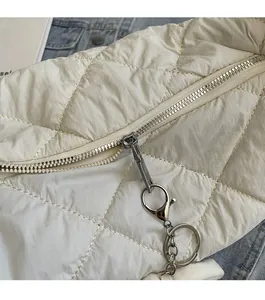 Detail van de soepele metalen rits en zilveren ringen op de witte gewatteerde tas