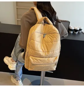 Quilted yellow backpack with padded shoulder straps and water-resistant nylon texture