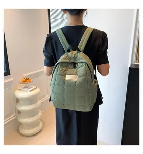 Detail eines hellgrünen gesteppten Rucksacks mit Wattierung an weiblichem Model
