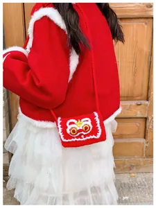 Close-up of a handmade red knitted lion dance crossbody bag for kids festive style