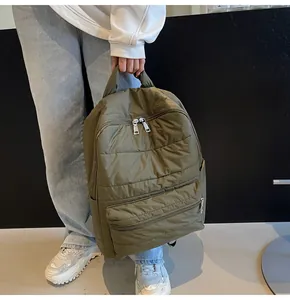 Detail of army green quilted backpack with large front pocket and padded design