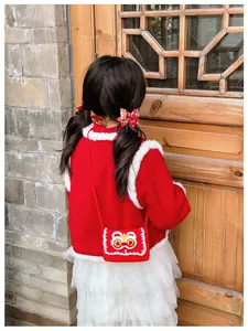 Detail of red knit lion crossbody bag paired with festive New Year outfit for kids