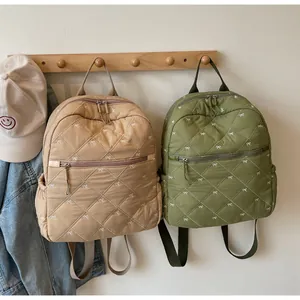 Close-up of quilted backpack details with bow embroidery and side storage pockets