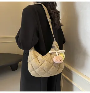Gevoerde hobo-tas met ruitpatroon en bloemenhanger gedragen door een model op de foto