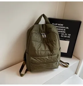 Detail view of the quilted olive green padded backpack with waterproof nylon texture