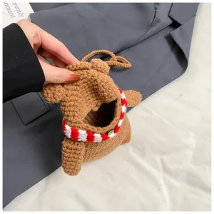 Detail of hand-crocheted brown bear mini bag with red-white striped scarf and snap closure