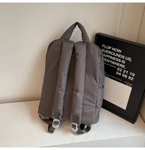 Detail of soft padded backpack straps and quilted nylon texture in dark grey