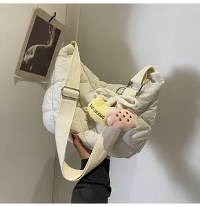 Detail van gebroken witte gewatteerde schoudertas met pluche hartjes en verstelbare riem
