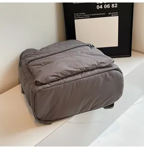 Close-up of a dark grey quilted backpack on a marble surface with modern decor