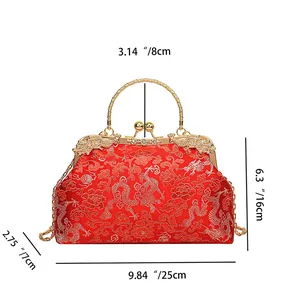 Detailed view of red bridal clutch with gold dragon embroidery and crystal swan accents