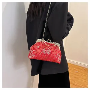 Detail of red vintage Chinese bridal bag with dragon embroidery and metal frame closure