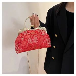 Detail of red satin evening bag with gold dragon embroidery and double dragon clasp