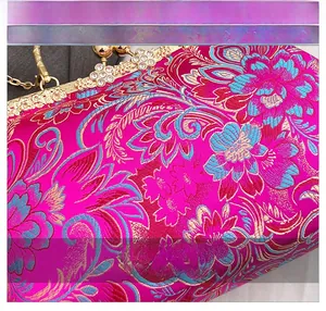 Detail of rose red satin fabric with floral embroidery and rhinestone gold frame