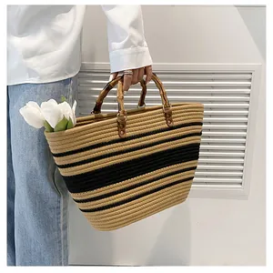 Detailed shot of striped woven tote bag with natural bamboo handle and brass ring hardware