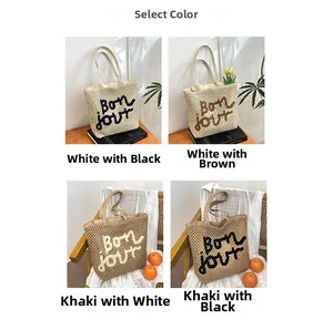 Macro display of woven straw bags with Bon jour embroidery in white and khaki colors