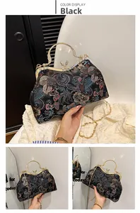 Detail of vintage black shell bag with colorful floral embroidery and gold chain strap