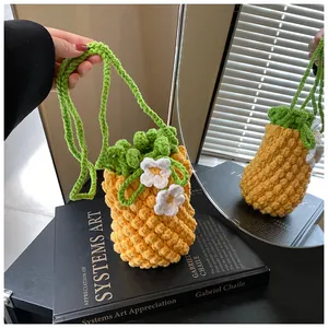 Close-up of handmade crochet pineapple bag featuring yellow texture and green leaf straps