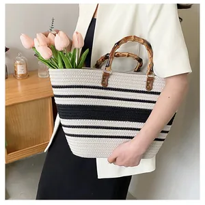 Detail of striped woven tote bag with bamboo handle and pink tulips inside