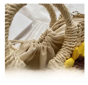 Close-up of beige straw handbag with yellow sunflower decor and drawstring liner