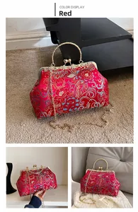 Macro detail of red silk embroidery handbag featuring a vintage metal clasp and chain