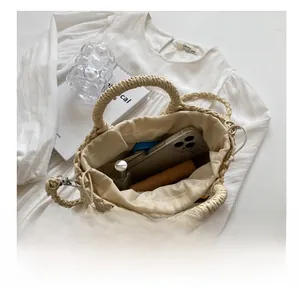 Interior view of straw handbag showing storage capacity with drawstring lining