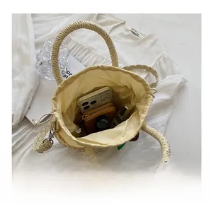 Detail view of woven straw bucket bag showing spacious interior with drawstring closure