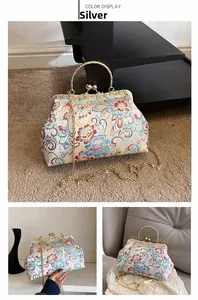 Detailed view of silver floral embroidery handbag with metal frame and gold handle