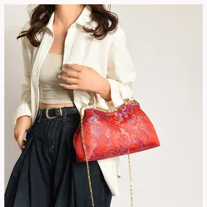 Detail of red Chinese silk embroidery handbag with golden frame and chain strap