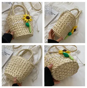 Detail view of woven bucket bag with Goodday embroidery and sunflower accent