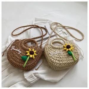 Detail of handwoven straw bags with sunflower charm and Goodday embroidery