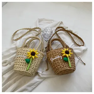 Detailed view of straw bucket bags with sunflower decor and Goodday lettering text