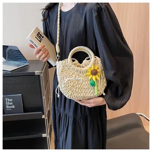 Detail of hand-woven beige straw bag with sunflower embroidery and drawstring liner