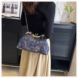 Detailed view of vintage blue floral brocade shell bag with gold chain and metal frame