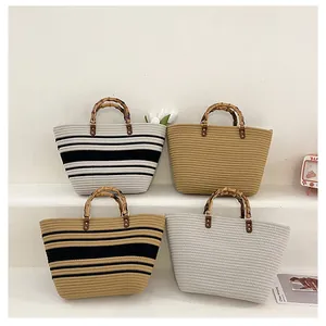 Detail of four straw tote bags with natural bamboo handles and textured weaving
