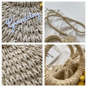 Detail view of woven straw bag with Good day embroidery and drawstring closure