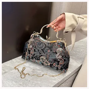 Detailed close-up of retro heavy embroidery evening bag with golden butterfly clasp