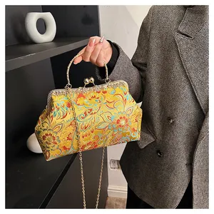 Detailed embroidery on a vintage Chinese silk handbag with golden ring handle and clasp