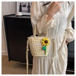 Detailed shot of straw bucket bag with sunflower decor and Goodday embroidery