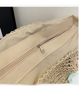 Detail shot of smooth metal zipper closure and fabric lining on woven straw beach bag