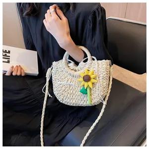 Detail of cream woven straw bag with sunflower embroidery and crossbody strap