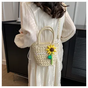 Detail of straw bucket bag with sunflower embroidery and Goodday artistic lettering