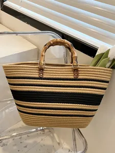 French straw woven tote with bamboo handles and chic black striped pattern for beach